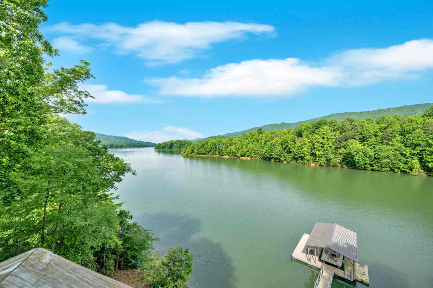 The view down the lake from above, with the covered dock at the water's edge below.